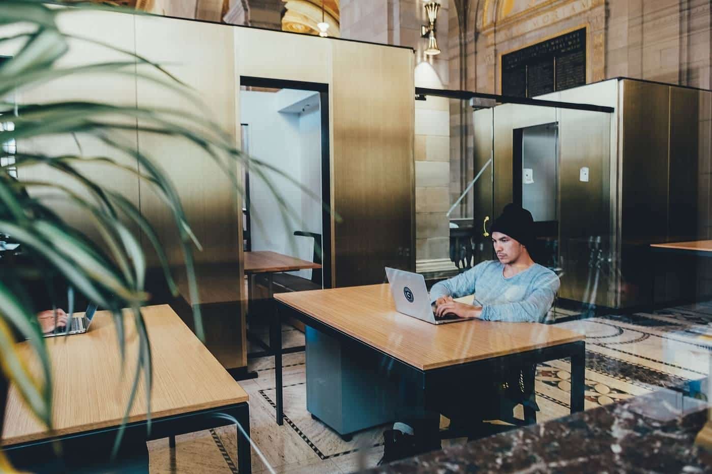 A person working at a laptop in a bright open workspace