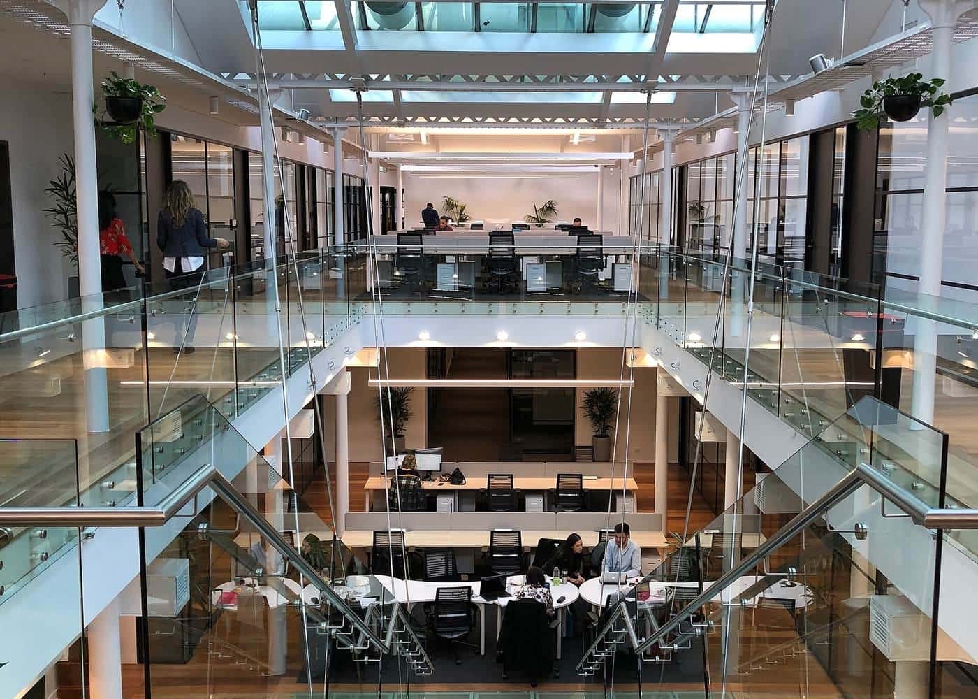 A multi-level coworking space in Melbourne with desks under a glass roof