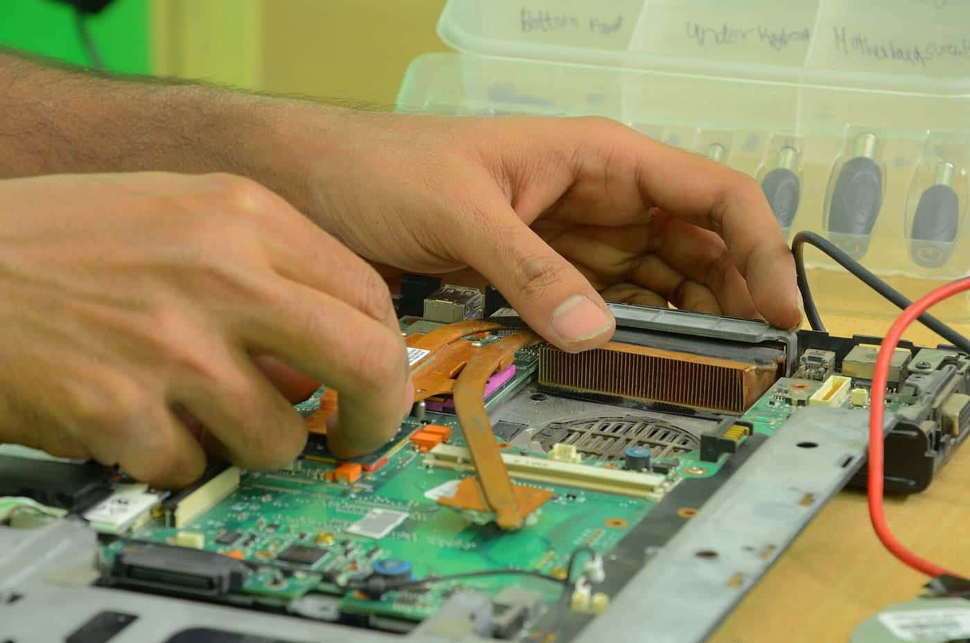 Hands repairing the inside of a computer