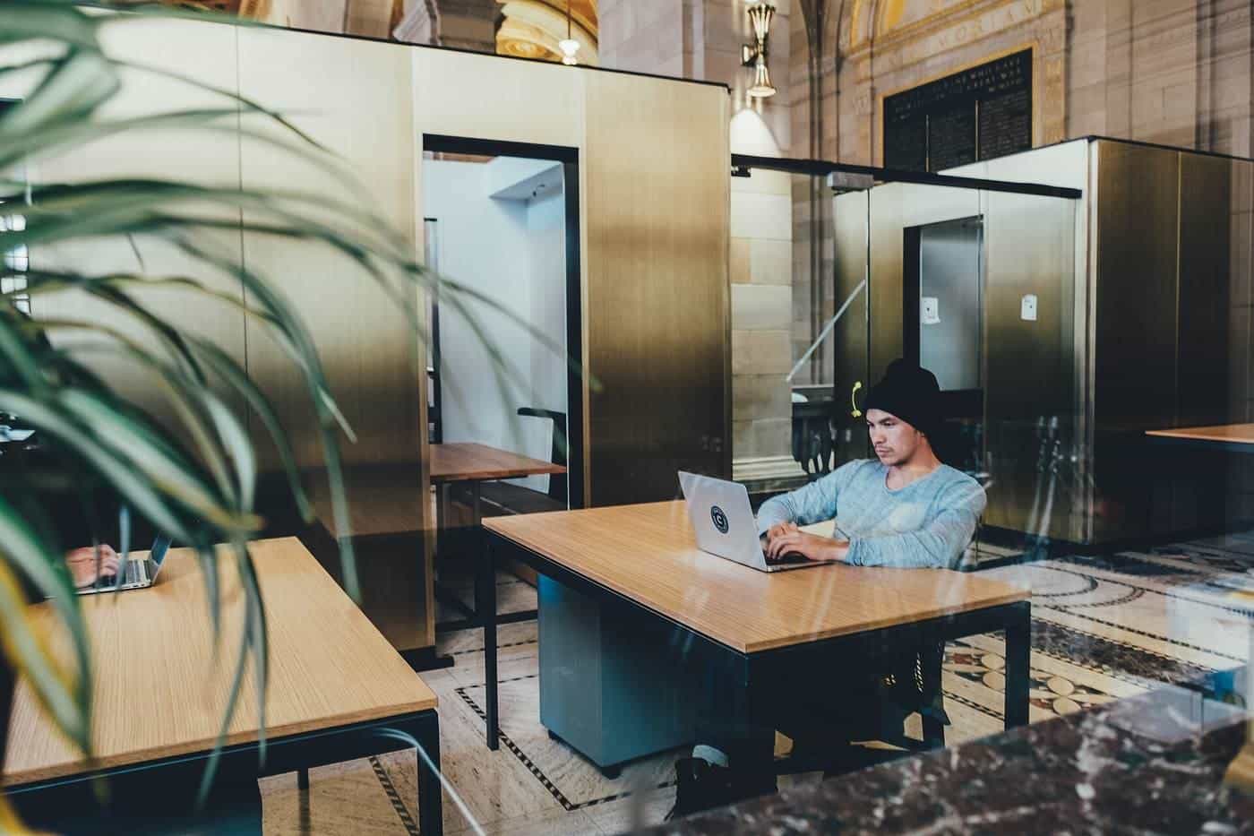 A person working at a laptop in a bright open workspace