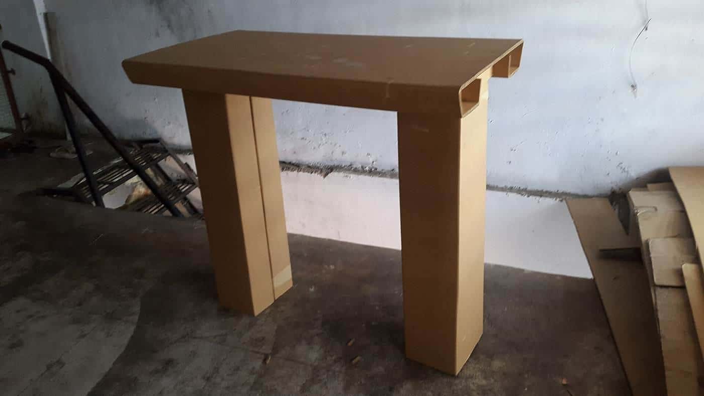 A simple cardboard standing desk riser on a table